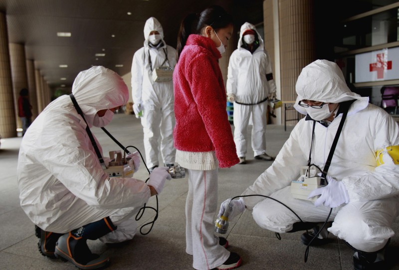In this March 24, 2011 file photo, a young evacuee is screened at a shelter for leaked radiation from the tsunami-ravaged Fukushima Dai-ichi nuclear plant in Fukushima, northeast of Tokyo. A new study says children living near the Fukushima nuclear meltdowns have been diagnosed with thyroid cancer at a rate 20 to 50 times that of children elsewhere, a difference the authors contend undermines the governments position that more cases have been discovered in the area only because of stringent monitoring. Most of the 370,000 children in Fukushima have been given ultrasound checkups since the March 2011 meltdowns at the tsunami-ravaged Fukushima Dai-ichi nuclear plant. Thyroid cancer has been diagnosed in 137 of those children, though more broadly the disease occurs in only about one or two of every million children. (AP Photo/Wally Santana, File)