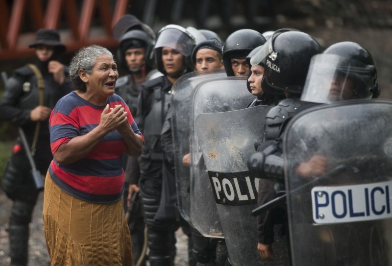 A woman pleads for the release of two residents who were detained by police during clashes in El Limon, Nicaragua, Saturday, Oct. 17, 2015. Riot police clashed with striking workers demanding the reinstatement of fired employees from the Canadian mining company B2Gold. (AP Photo/Esteban Felix)