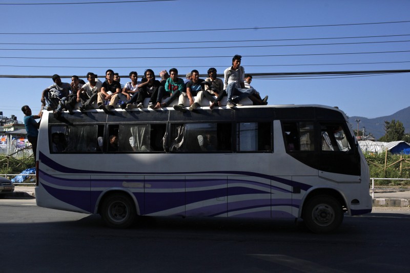 Nepalese people crowd the roof of a public bus in Kathmandu, Nepal, Thursday, Oct. 8, 2015. Struggling with a fuel shortage after Indian shipments went on hold, Nepal is asking suppliers to bring gasoline and kerosene by airplane before the Himalayan country begins celebrating its biggest festival of the year, and for the first time is looking to import fuel from China. (AP Photo/Niranjan Shrestha)