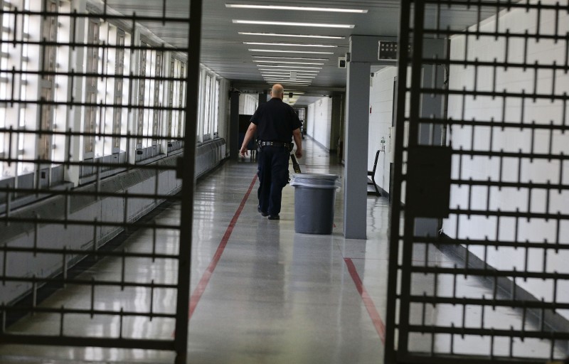 A Rikers Island juvenile detention facility officer walks down a hallway of the jail, Thursday, July 31, 2014, in New York. (AP Photo/Julie Jacobson)