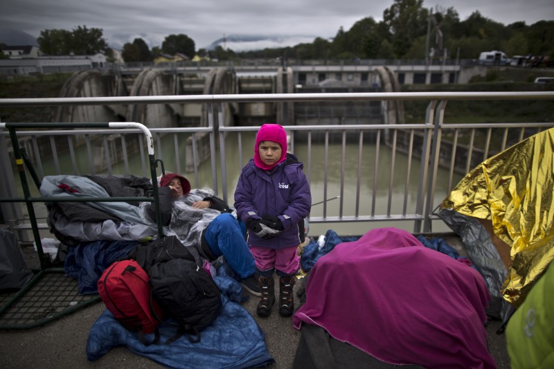 In this photo taken on Thursday, Sept. 24, 2015, Syrian refugee Abdulwahab Alabdullah, 5, who came with his family from Aleppo, Syria, poses for a picture while waiting on a bridge after they spent the night waiting for their registration and transport by German police to a refugee shelter in Freilassing, Germany. "I am so cold waiting with my father and mother and younger brother from two days in this bridge," he said. (AP Photo/Muhammed Muheisen)