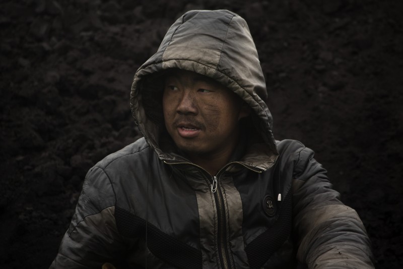 In this Tuesday, Nov. 3, 2015 photo, a worker takes a break at an idled coal mine near Ordos in northern China's Inner Mongolia Autonomous Region. Demand for coal is leveling off, but it will remain a key energy source for decades, and its future is closely tied to China, the worlds biggest coal user, producer and importer. It burns 4 billion tons of coal a year, four times as much as the United States. (AP Photo/Mark Schiefelbein)