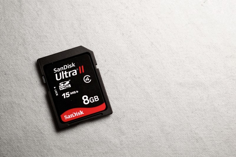 File: An 8-gigabyte SD card rests on a pale, textured background. For enhanced security, journalists can record and encrypt voice onto SD cards in soundproof rooms, then physically share the data with another. (Flickr / Cristiano Betta)