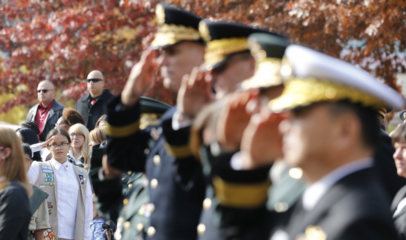 A member of the Girl Scouts Overseas Korea, left, salutes with U.S. and South Korean soldiers during the Veterans Day Ceremony in front of the 8th Army War Memorial at Yongsan Main Post in Seoul, South Korea, Wednesday, Nov. 11, 2015. (AP Photo/Lee Jin-man)