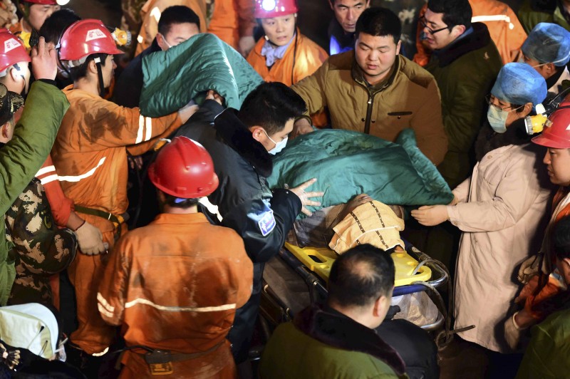 In this Dec. 25, 2015 photo released by China's Xinhua News Agency, a trapped miner is rescued from a collapsed gypsum mine in Pingyi County, east China's Shandong Province. Chinese rescuers pulled more than 10 workers to safety and located another workers who were trapped after a mine collapsed in the eastern province of Shandong, state media said Saturday. (Guo Xulei/Xinhua via AP) NO SALES
