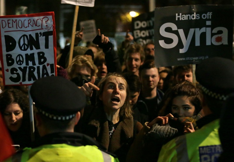 Protesters react outside the Houses of Parliament, in London, Wednesday, Dec. 2, 2015 after UK lawmakers voted 397-223 to launch airstrikes against Islamic State group in Syria. (AP Photo/Tim Ireland)