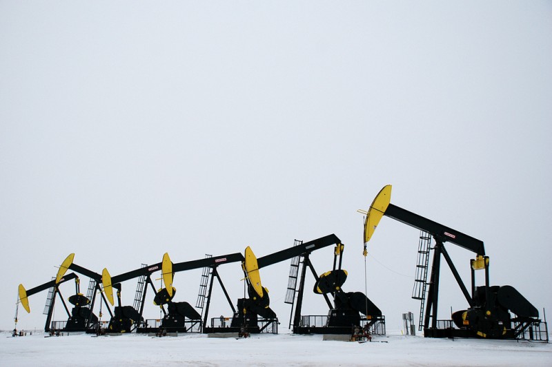 In this December 24, 2012 photograph, a row of oil derricks operate in a snowy field near Tioga, North Dakota. (Flickr / Geof Wilson)