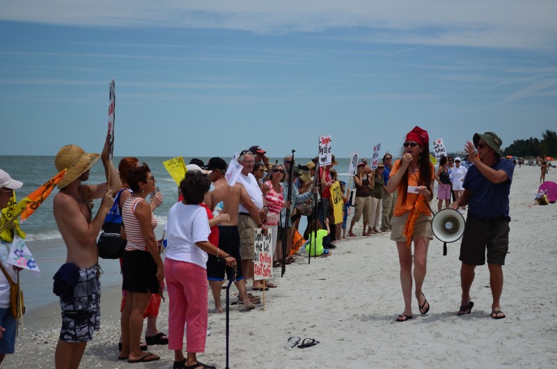 In this May 17, 2014 photograph, anti-fracking protesters line the beach at the "Hands Across the Sand" protest at Naples Pier. (Flickr / Linda Space Jacobson)