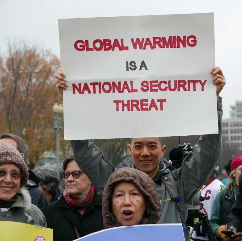 In this Nov. 29, 2015 photograph, an activist holds a sign that reads "Global Warming Is A National Security Issue" at a protest in Washington, D.C. (Flickr / Susan Melkisethian)