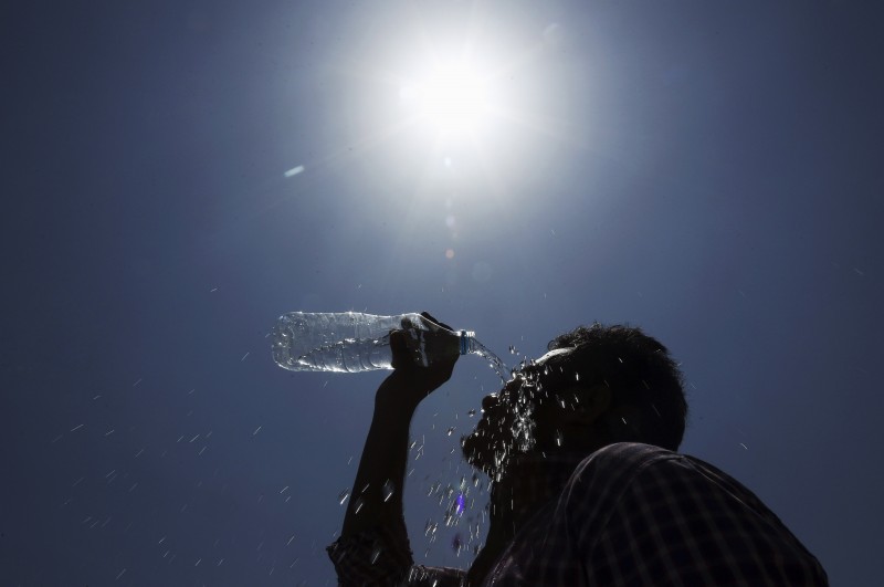 In this May 24, 2015 file photo, a man pours water on his face during a hot summer day in Hyderabad, India. Climate change doubters may have lost one of their key talking points: a particular satellite temperature dataset that had seemed to show no warming for the past 18 years. (AP Photo/Mahesh Kumar A., File)