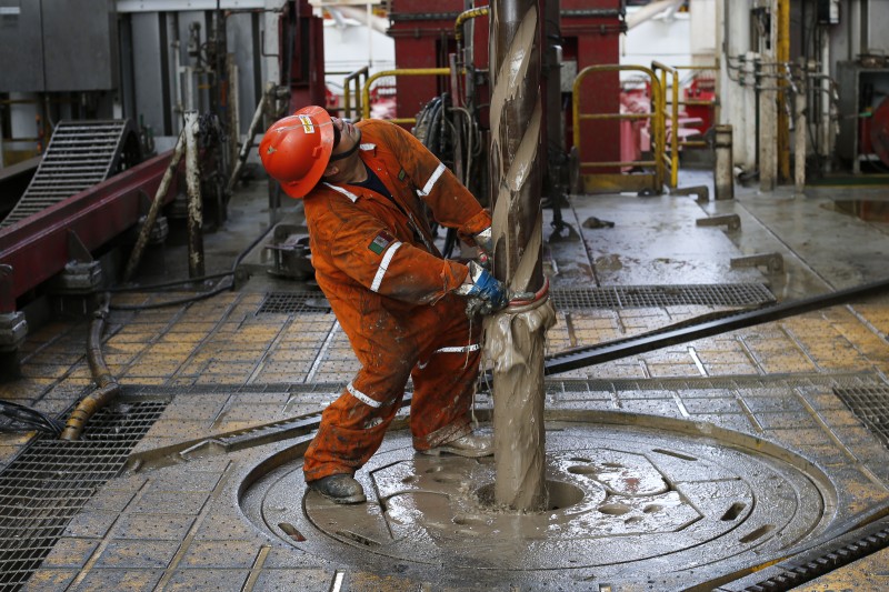 In this Nov. 22, 2013 file photo, oil worker Vicente Gonzalez looks up as the drill is pulled upwards on the Centenario deep-water drilling platform off the coast of Veracruz, Mexico in the Gulf of Mexico. Mexicos state-run oil company said Monday,Feb. 29, 2016, that it is halting some of its exploration and production projects in an attempt to counter the effects of the drop in international oil prices. (AP Photo/Dario Lopez-Mills, File)