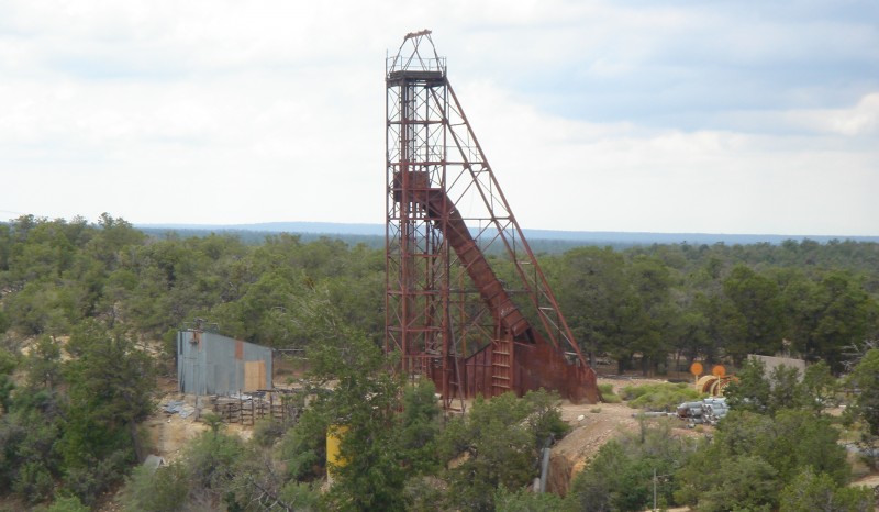 A rusted metal frame surrounded by trees and brush rises above an open pit uranium mine in Utah in this July 30, 2006 photograph. (Flickr / John Lutz)