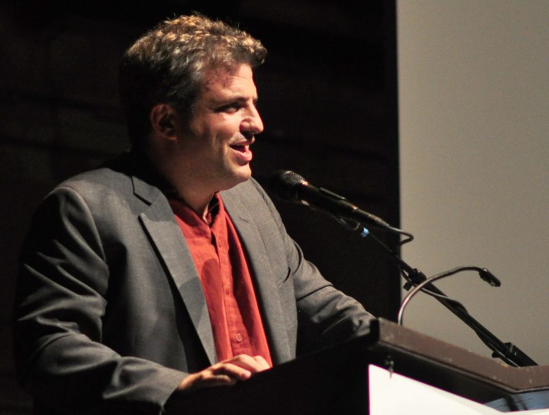 Dave Zirin speaks at a podium on October 15, 2015 in Seattle. (Flickr / Joe Mabel)