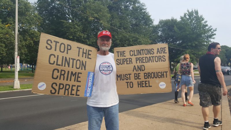 At the "March for Our Lives" event in Philadelphia at the 2016 Democratic National Convention, a man holds signs accusing the Clinton's of being "superpredators." July 25, 2016. (Kit O'Connell)