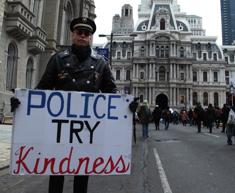 In this January 19, 2015 photograph, former Philadelphia police Capt. Ray Lewis holds a sign that reads "Police: Try Kindness." (Flickr / Meredith Nutting)