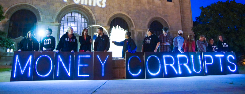 July 9, 2014. Members of the Overpass Light Brigade hold lit signs spelling out "MONEY CORRUPTS" in Milwaukee, Wisconsin. (Flickr / Joe Brusky) 