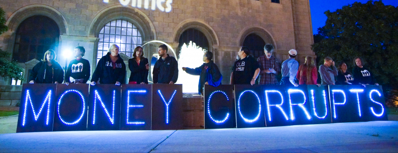 July 9, 2014. Members of the Overpass Light Brigade hold lit signs spelling out "MONEY CORRUPTS" in Milwaukee, Wisconsin. (Flickr / Joe Brusky)