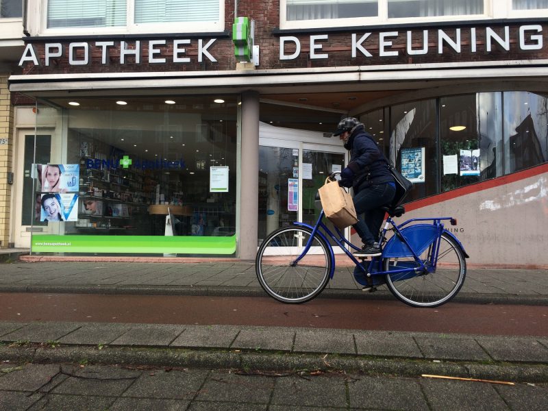 A cyclist with a shopping bag rides past a pharmacy in Rotterdam. January 14, 2015. (Flickr / M. Appelman)