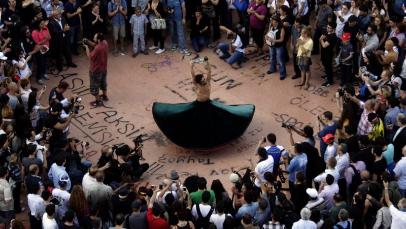 A whirling dervish holding a gas mask performs in Taksim square of Istanbul, Wednesday, June 5, 2013. Tens of thousands of Turks have joined anti-government protests the last five days expressing discontent with Prime Minister Recep Tayyip Erdogan's 10-year rule. (AP Photo/Kostas Tsironis)