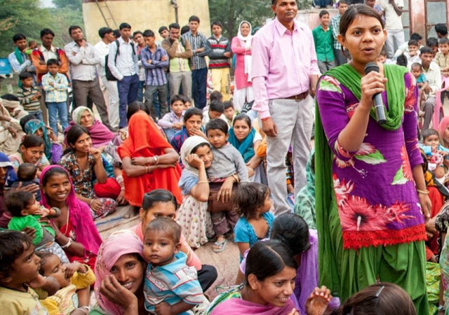 A community of women and girls gather in a village. (Girl Rising)