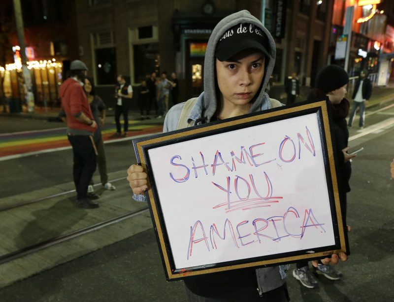 Felomina Cervantes, of Seattle, holds a sign that reads "Shame on You America" as she takes part in a protest against President-elect Donald Trump, Wednesday, Nov. 9, 2016, in Seattle's Capitol Hill neighborhood. (AP Photo/Ted S. Warren)