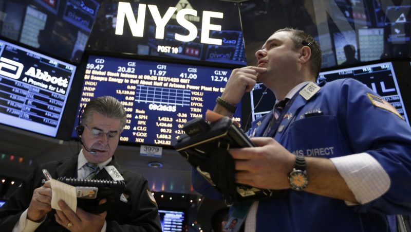In this Wednesday, Dec. 26, 2012, photo, Daniel Kryger, left, and Kevin Lodewick Jr., right, work on the floor of the New York Stock Exchange in New York. (AP Photo/Kathy Willens)