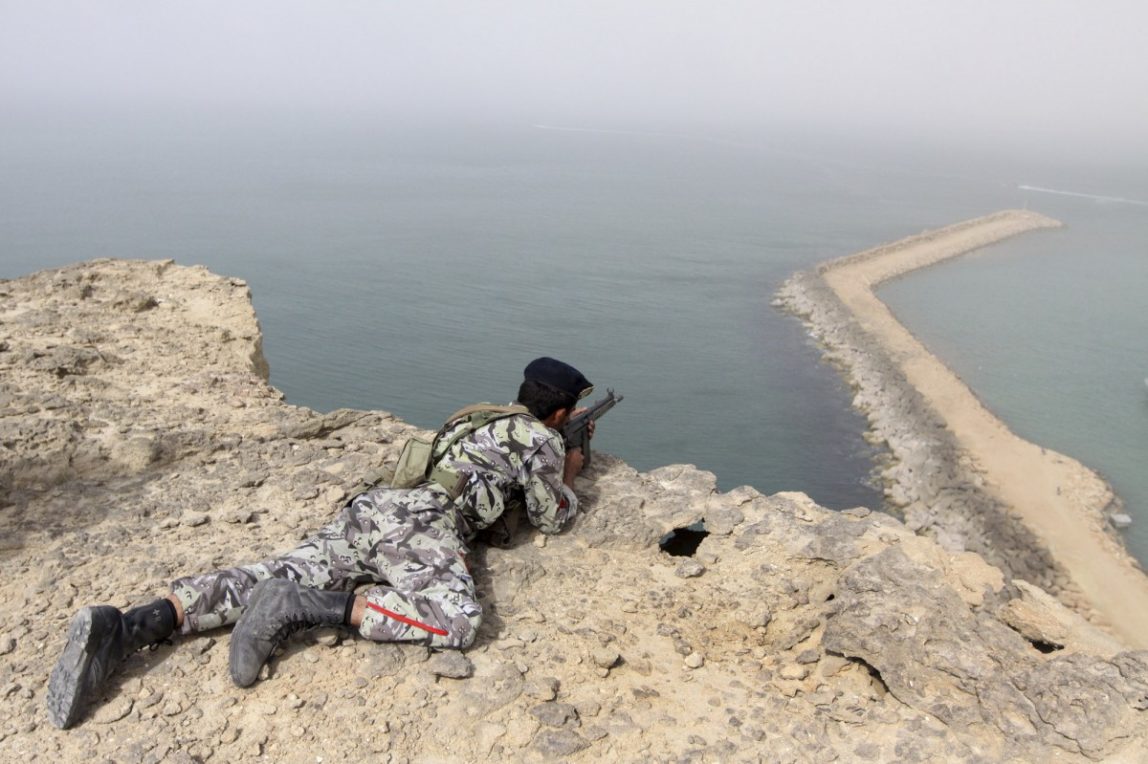 In this Friday, Dec. 30, 2011 file photo, a member of the Iranian military takes position in a drill on the shore of the sea of Oman. During a graduation at Iran's main army academy, the country's leader effectively sketched out the Islamic Republic's tougher military posture. Iran's must never hesitate to display its power in a hard-edged world where the weak pay the price, he told the newly minted officers. Less than two months later, Khamenei's words were echoed by commanders who warned that Iran could block oil tanker shipping lanes in the Gulf in retaliation for sanctions and described foreign forces, including a recent visit by an U.S. aircraft carrier, as unwelcome interlopers in the region. (AP Photo/YJC, Mohammad Ali Marizad, File)
