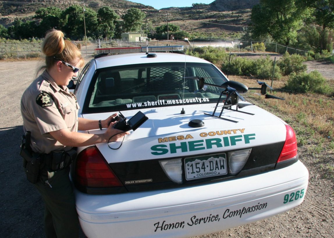 This undated photo provided by the Mesa County, Colo. Sheriff's Department, Deputy Amanda Hill of the Mesa County Sheriffs Office in Colorado prepares to use a Draganflyer X6 drone equipped with a video camera to help search for a suspect in a knife attack in Mesa County, Colo. (AP Photo/Mesa County Sheriff's Unmanned Operations Team)
