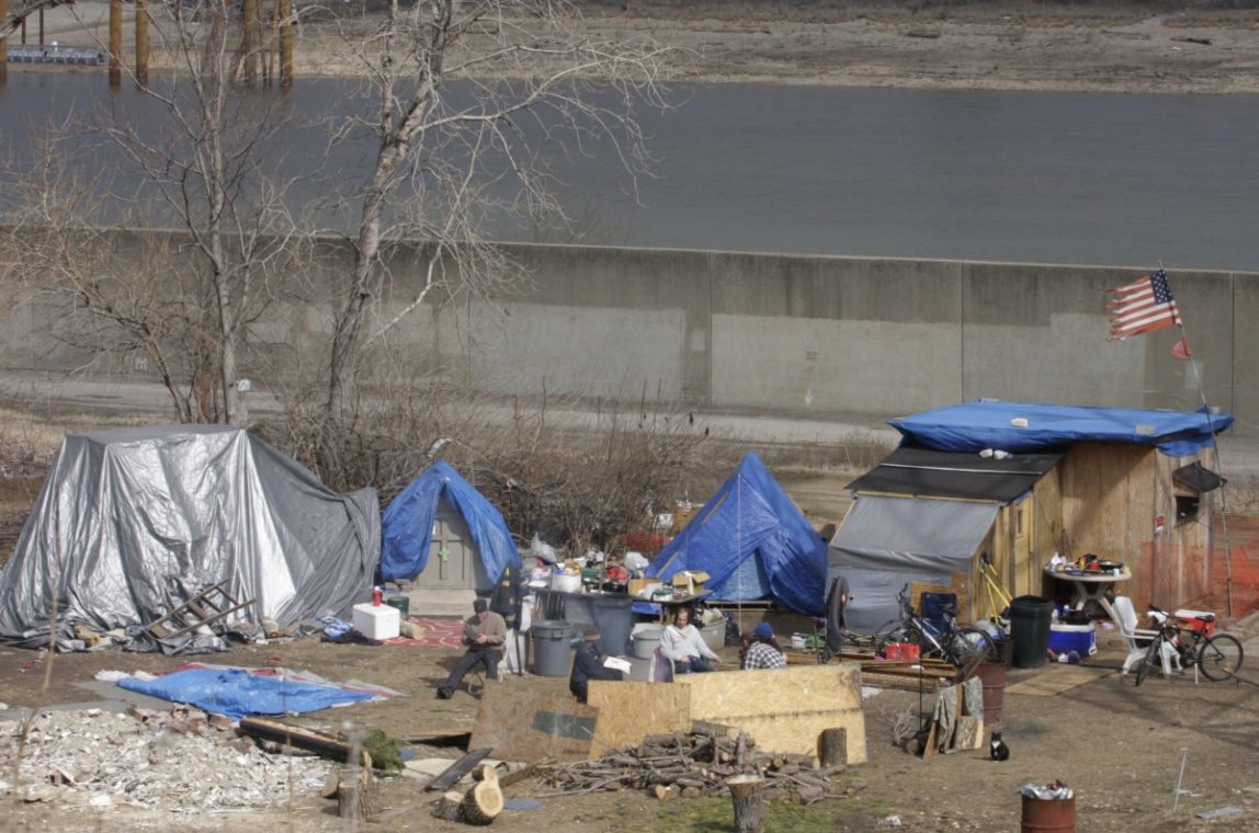 A group of homeless people sit around the fire at their homeless encampment near the Mississipi river, Thursday, Feb. 23, 2012 in St. Louis. (AP Photo/Tom Gannam)