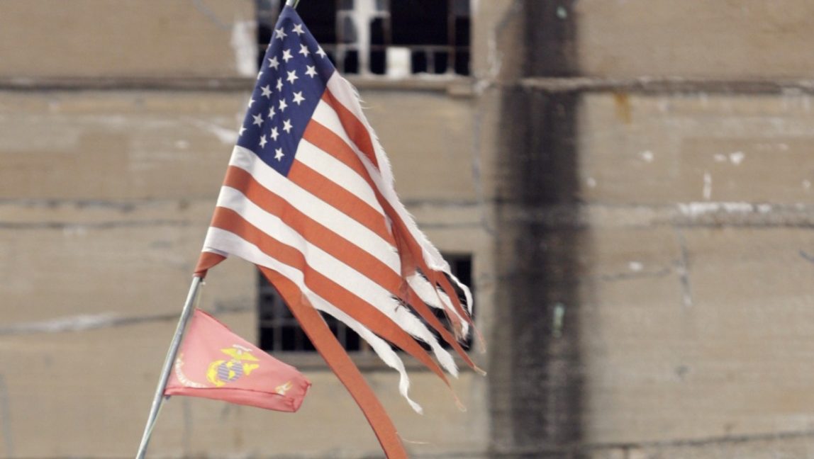 A tattered American flag flies over a homeless encampment, Thursday, Feb. 23, 2012 in St. Louis. (AP Photo/Tom Gannam)