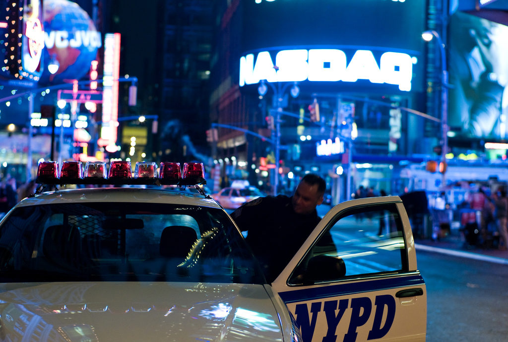 An officer gets into an NYPD vehicle. (Photo by Joi Ito)