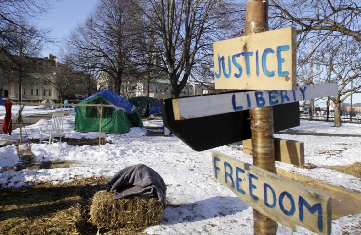 A few remaining tents and sign are seen before being dismantled at the Occupy Maine encampment in Lincoln Park in Portland, Maine, on Monday, Feb. 6, 2012. A deadline for Occupy Maine to dismantle its encampment came and went Monday morning with no action by police, and several tents remained in Lincoln Park. (AP Photo/Pat Wellenbach)