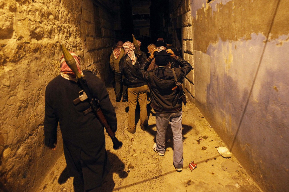 Syrian rebels walk in an alley in Idlib, Syria, Wednesday, Feb. 8, 2012. (AP Photo)