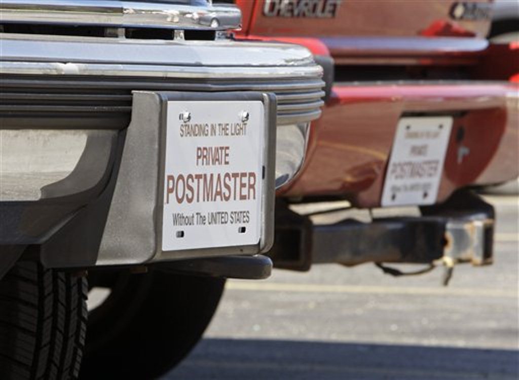 In this July 2, 2010 photo, two vehicles with no registered license plates are parked outside an apartment complex in Columbus, Ohio. James T. McBride, a member of the Sovereign Citizens movement, owns the vehicles and claims he doesn't have to register them because the U.S. government has no authority over citizens. (AP Photo/Jay LaPrete)