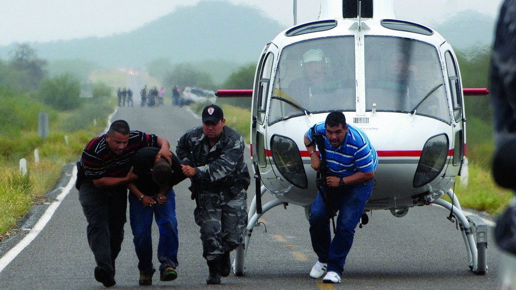 Police take a suspected drug trafficker off a helicopter in Hermosillo in the state of Sonora. Journalists who print names or photographs of cartel members risk their lives. As a result, many papers in Northern Mexico have stopped reporting on drug violence. (Photo courtesy of the Knight Foundation)