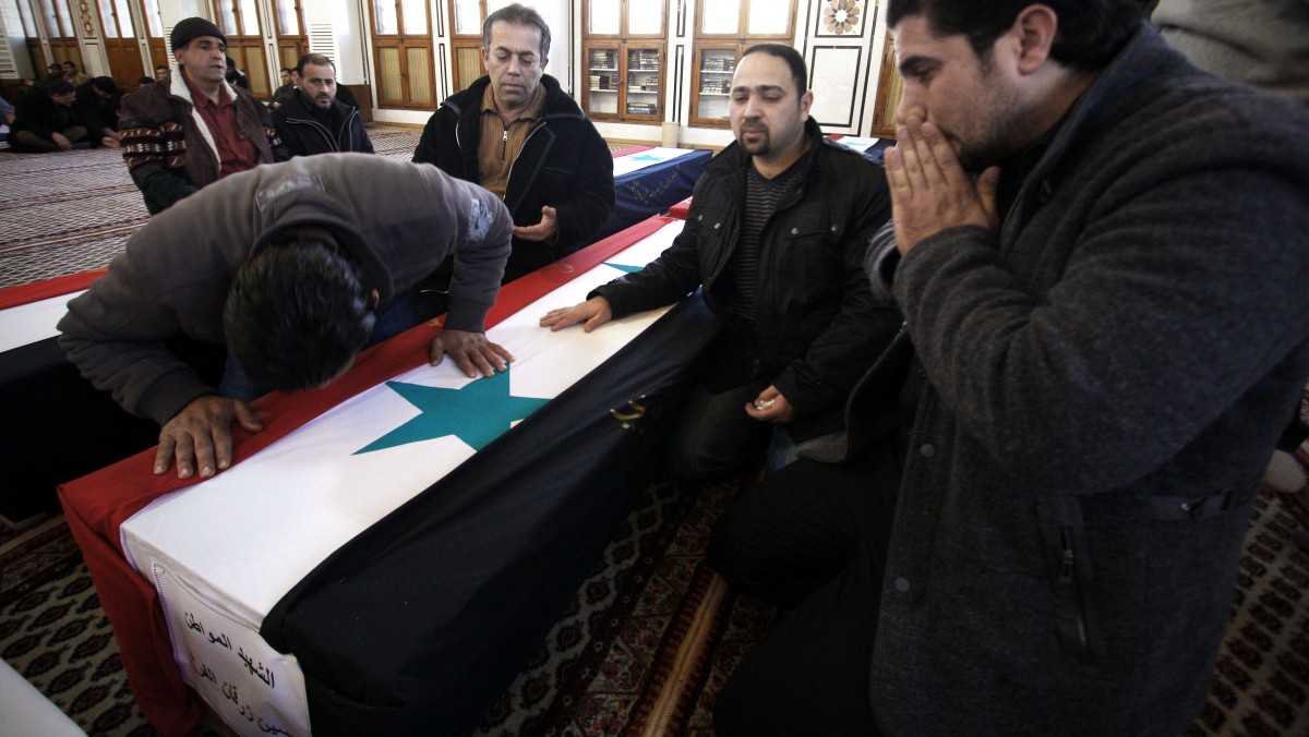Men react at a funeral of the victims killed during a suicide bombing attack in Damascus, Syria, Sunday, March 18, 2012. Three suicide bombings in Damascus on Saturday killed several people. The government blamed those on the opposition, which it claims is made up of "terrorist" groups carrying out a foreign conspiracy. (AP Photo/Muzaffar Salman)