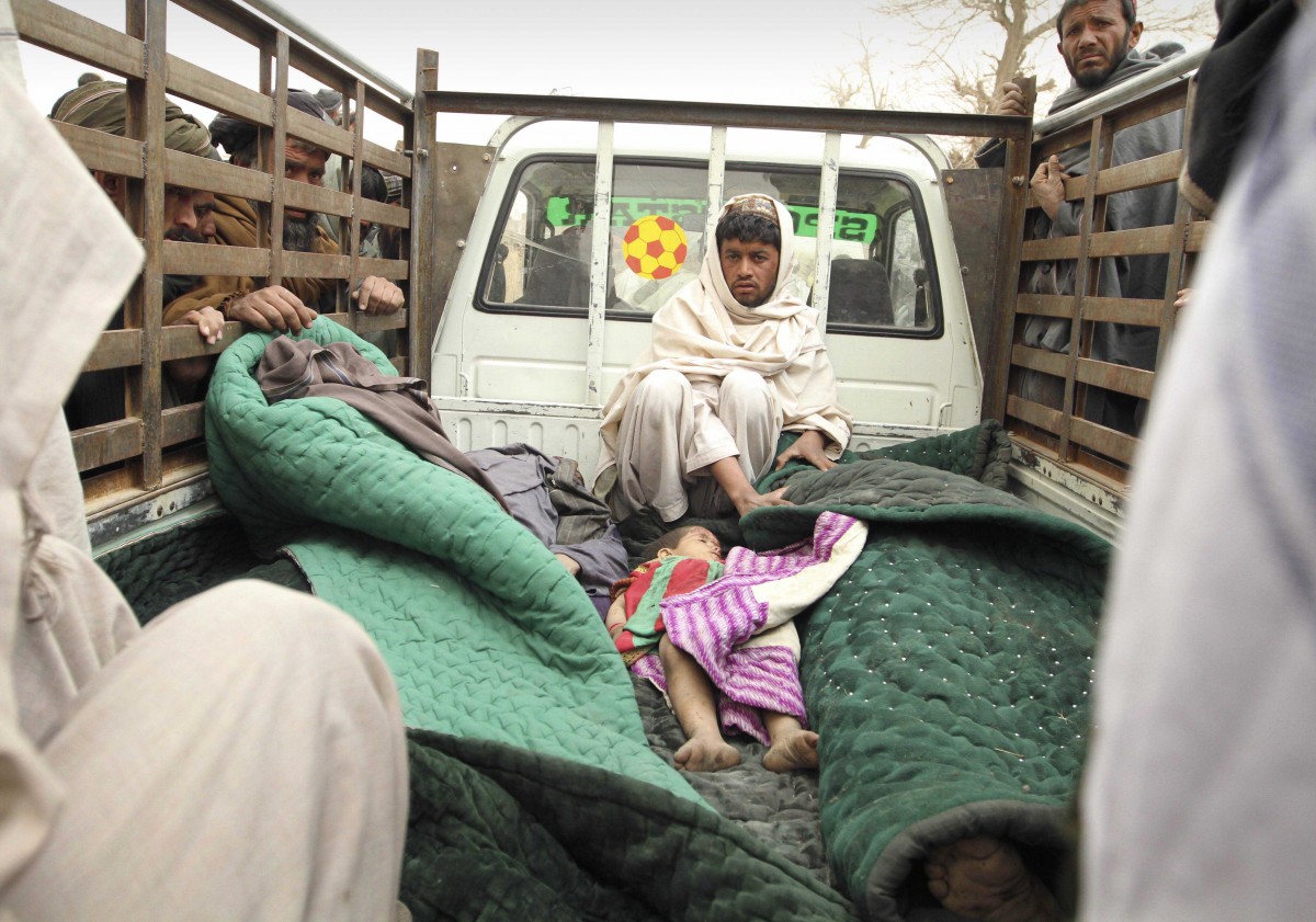 A man sits in the back of a truck with the bodies of several men and a child allegedly killed by a U.S. service member in Panjwai, Kandahar province south of Kabul, Afghanistan, Sunday, March 11, 2012. A U.S. service member walked out of a base in southern Afghanistan before dawn Sunday and started shooting Afghan civilians, according to villagers and Afghan and NATO officials. Villagers showed an Associated Press photographer 15 bodies, including women and children, and alleged they were killed by the American. (AP Photo/Allauddin Khan)