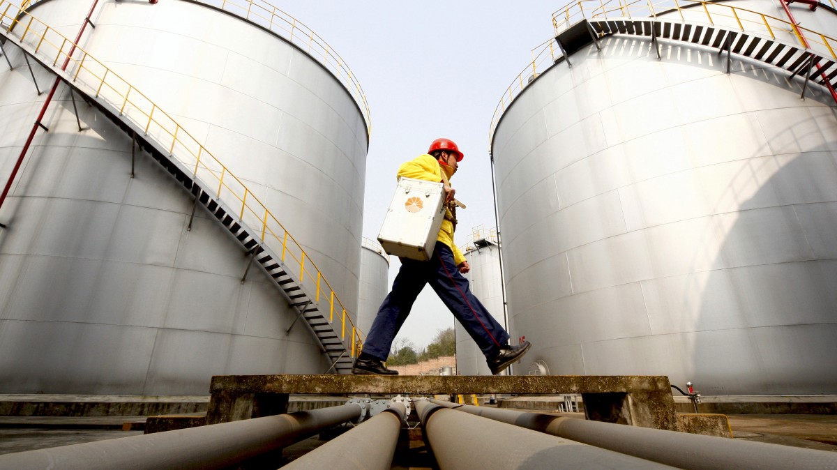 In this Thursday, Jan. 28, 2010 file photo, a worker walks past tanks at a Petrochina storage base. (AP Photo)