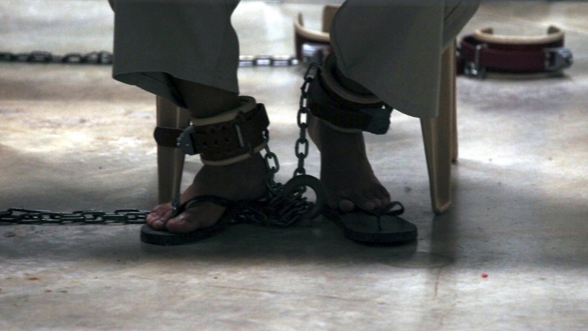 In this March 29, 2010 file photo, reviewed by the U.S. military and photographed through one-way glass, a Guantanamo detainee is shackled to the floor while attending a class in "Life Skills" at Camp 6 high-security detention facility at Guantanamo Bay U.S. Naval Base, Cuba. (AP Photo/Brennan Linsley, File)