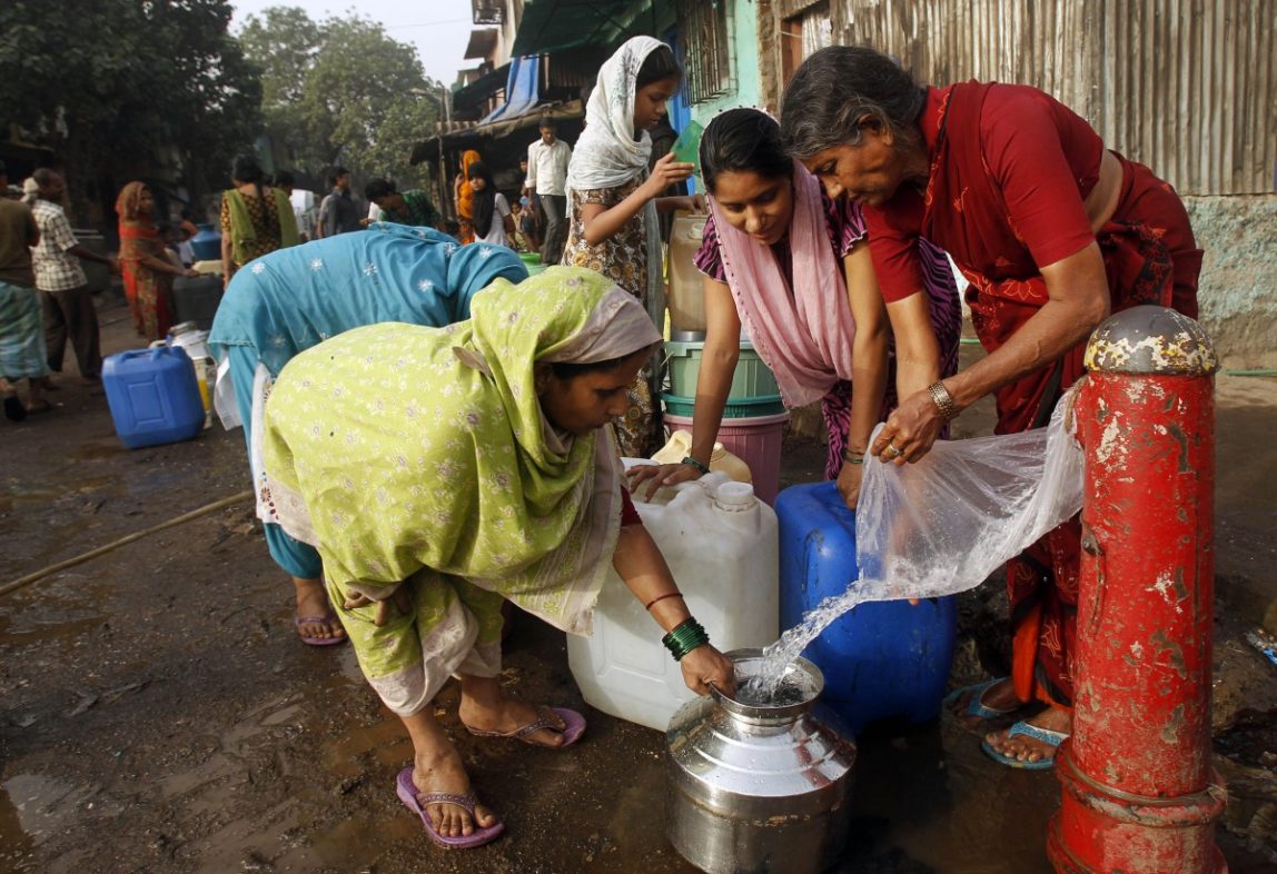 Indian women collect water from a broken pipe in a slum on the outskirts of Mumbai, India, Thursday, March 22, 2012. (AP Photo/Rafiq Maqbool)