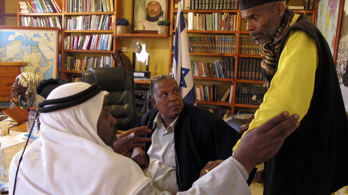 In this photo taken Tuesday, March 6, 2012, from right to left, Sheik Ayed al-Abed and Mohammed al-Masri and Khazrail Ben-Yehuda talk in a meeting room in the southern Israeli city of Dimona. For years, Israel's array of African communities had little interaction, divided by religious, linguistic and cultural differences that made it impossible to think about one another. But in an unprecedented gathering, some members of these communities, including Jewish Ethiopians, nomadic Muslim Arabs and migrants from Eritrea and Sudan are banding together, claiming their shared skin tone has given them a common experience of discrimination. (AP Photo/Diaa Hadid)