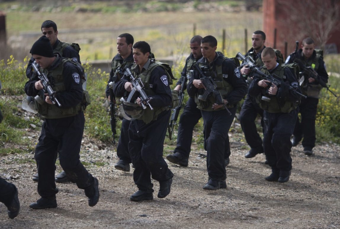 Israeli riot police men march along the border between Majdal Shams in the Golan Heights, and Syria, as security is tightened ahead of Land Day, Friday, March 30, 2012. March 30 is traditionally marked by Israeli Arabs as "Land Day," a time of protests against the confiscation of Arab-owned lands by Israel. In recent years, Palestinians have joined in. (AP Photo/Ariel Schalit)