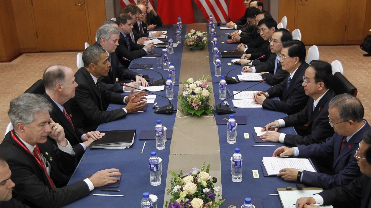 US President Barack Obama, left, sits across the table from Chinese President Hu Jintao, right, during the start of their bilateral meeting in Seoul, South Korea, Monday, March, 26, 2012. Sitting with them are members of both the US and Chinese delegations. (AP Photo/Pablo Martinez Monsivais)