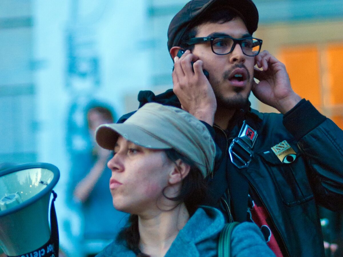 Protestors like the ones pictured above at a rally in Berkeley, CA often rely on cell phone communications to organize. (Photo by Keoki Seu)
