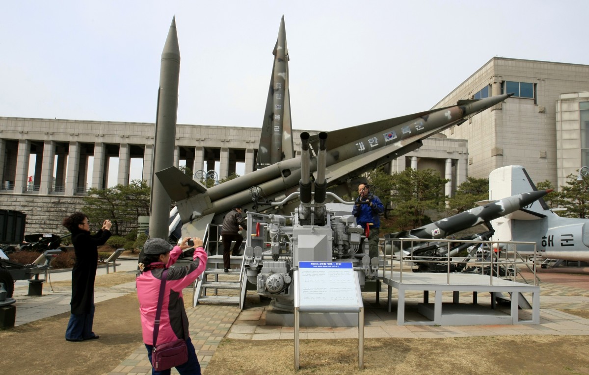 Foreign visitors take their souvenir photos near the displayed of mock North Korea's Scud-B missile, back left, and other South Korean missiles at Korea War Memorial Museum in Seoul, Monday, March 19, 2012. North Korea vowed Sunday to go ahead with plans to launch a long-range rocket, rejecting criticism in the West that it would scuttle recent diplomacy. (AP Photo/Lee Jin-man)