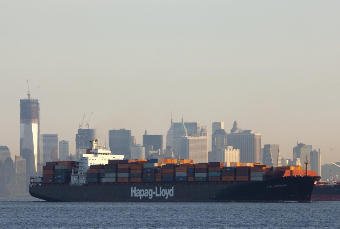 In this photo of Feb. 4, 2012, a cargo ship, owned by German shipping company Hapag-Lloyd, crosses New York Harbor. The U.S. trade deficit widened in December, reflecting a jump in imports of autos and industrial machinery. For the year, the deficit climbed to the highest level since 2008 as both exports and imports rose to all-time highs. (AP Photo/Mark Lennihan)