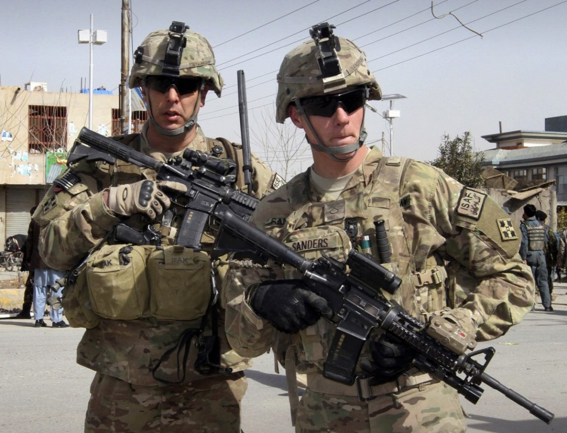 In this Feb. 5, 2012 file photo, U.S. soldiers part of the NATO- led International Security Assistace Force (ISAF) are seen alert at the scene of a suicide attack in Kandahar, south of Kabul, Afghanistan. (AP Photo/Allauddin Khan, File)