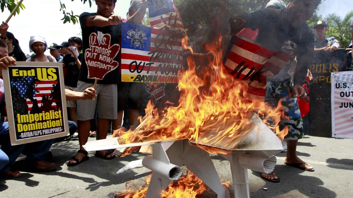 Protesters burn an effigy of a US military drone during a rally at the US Embassy in Manila, Philippines Friday April 13, 2012. (AP Photo/Bullit Marquez)