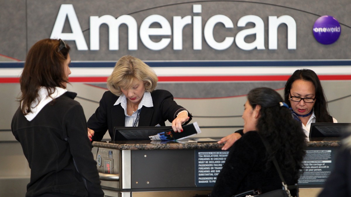 FILE - In this Nov. 29, 2011, file photo, an American Airlines employee helps passengers check-in at a ticketing counter at Dallas Fort Worth Airport in Dallas. American Airlines told a bankruptcy judge Monday that in order for the company to survive, it must break labor agreements that workers fought decades to win. (AP Photo/Richard W. Rodriguez, File)