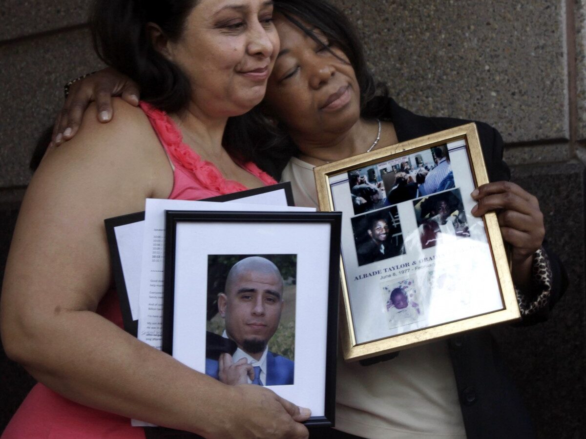 Ronnie Sandoval, left, Lorrain Taylor, comfort each other as they hold photos of their slain children, and a news conference where they joined others in supporting a Novemer 2012 ballot intiative to end the death penalty, held in Sacramento, Calif. Monday, Aug. 29, 2011. Sandoval's son, Arthur Carmona, was murdered in Santa Ana in 2008 and Taylor's twin sons with gunned down together in Oakland in 2000. Both mothers spoke against the death penalty and support the initiative that would replace capital punishment with life prison terms. (AP Photo/Rich Pedroncelli)